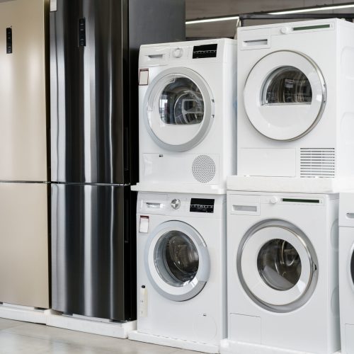 Row of new washing and drying machines in a hypermarket